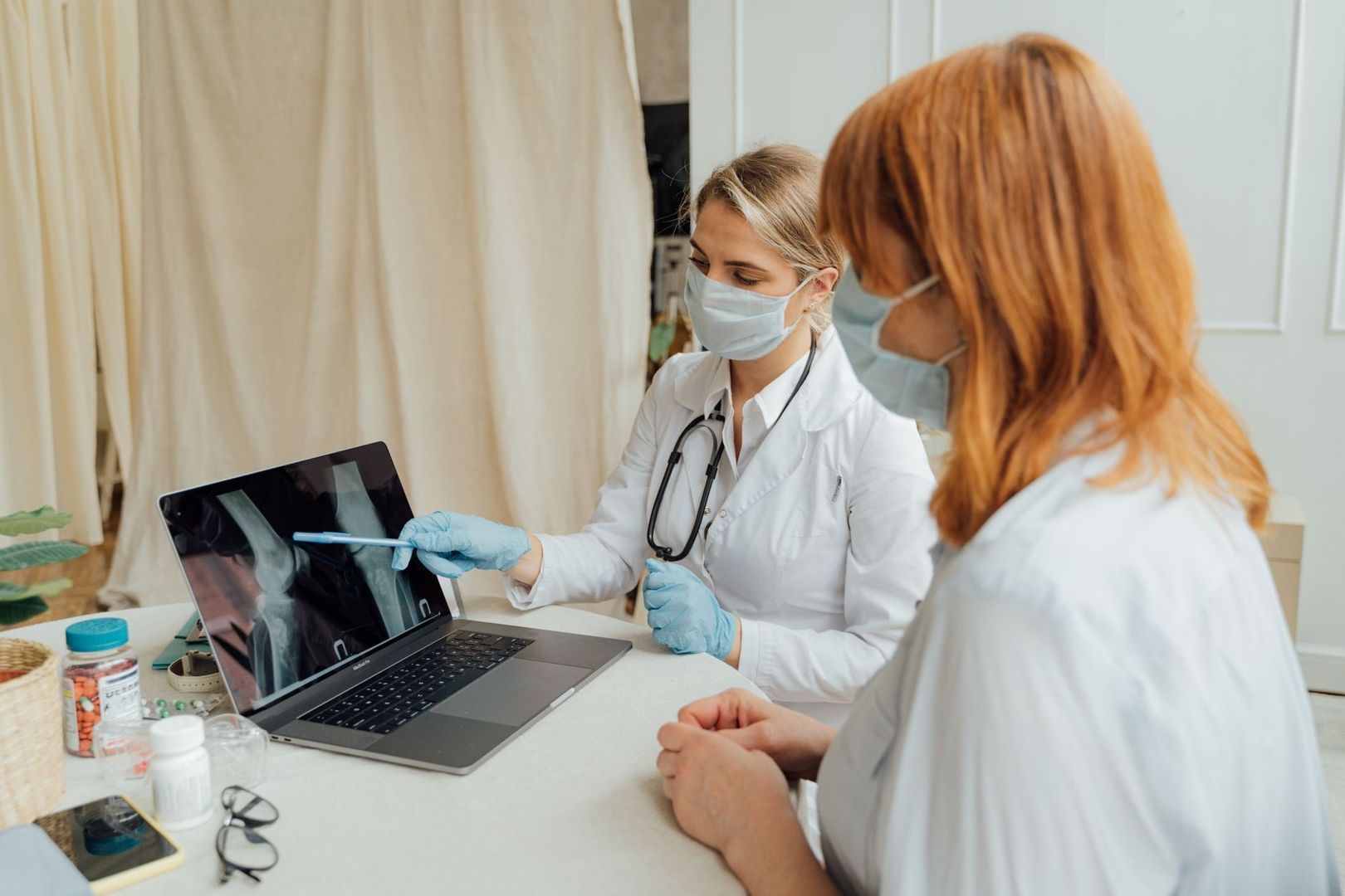 Ärztin bespricht ein Röntgenbild eines Gelenks mit einer Patientin