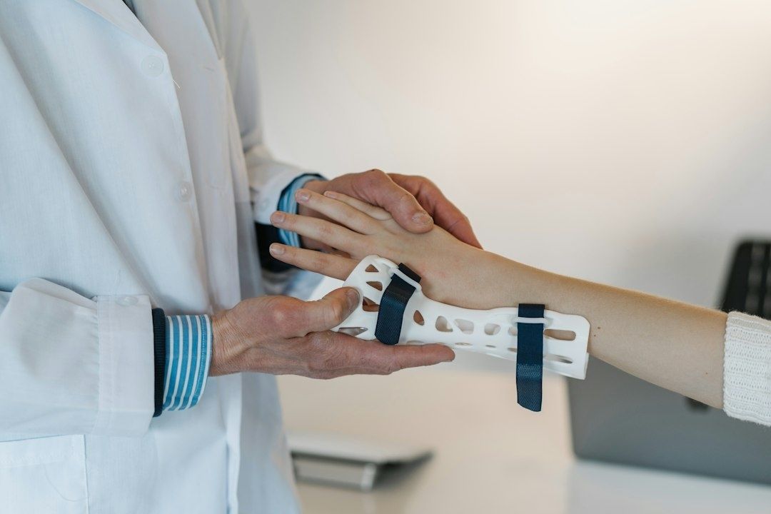 Arzt legt einer Patientin eine Handgelenkschiene an